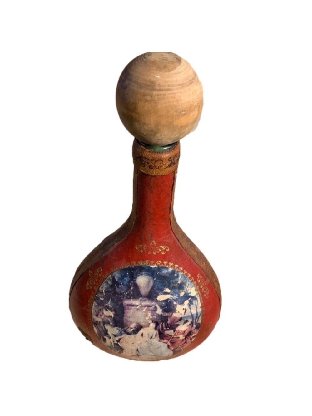 Red leather wrapped liquor bottle with picture on the front and gold detailing.